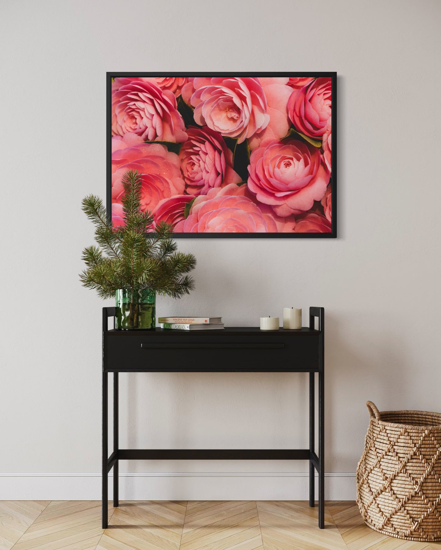Framed floral artwork above a black console table with decorative items.