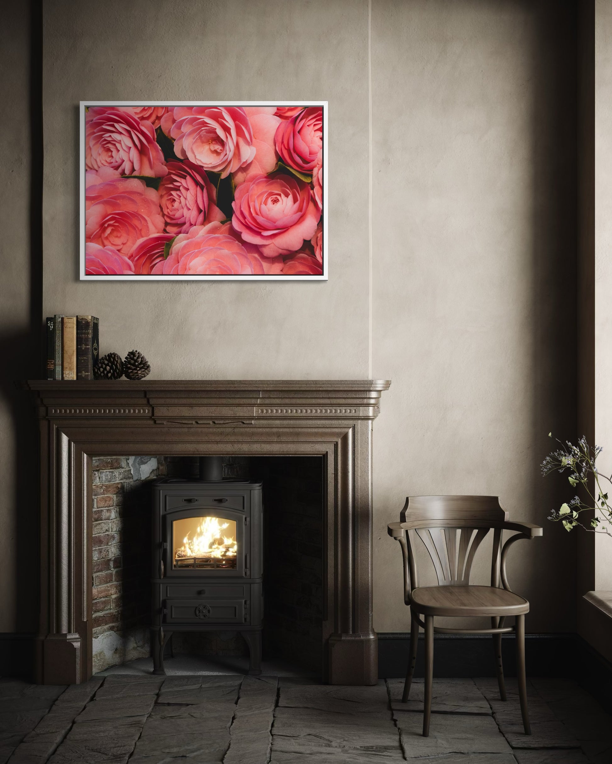 Framed floral artwork above a fireplace with a chair and decorative items in a room.